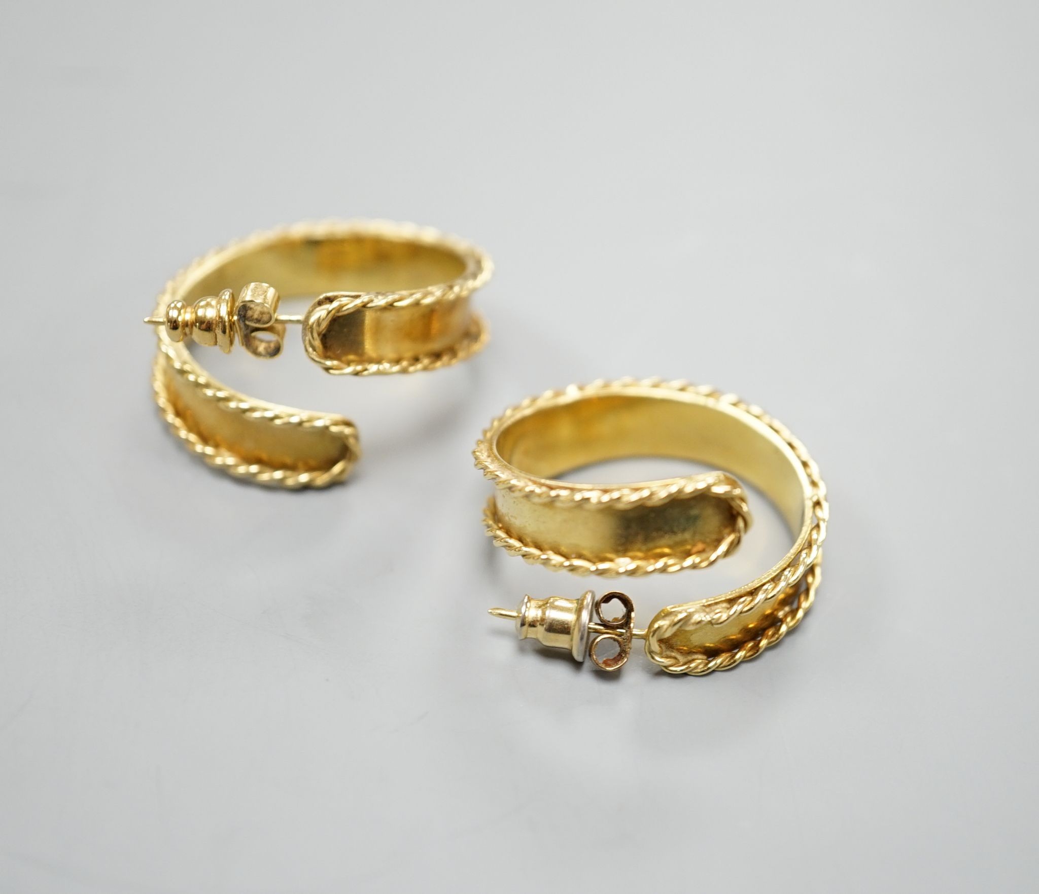 A pair of modern 18ct gold hoop earrings, with decorated borders, 27mm